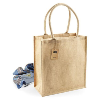 Jutetasche Boutique Shopper W409 Einkaufstasche mit langen aberundeten Henkeln und einer Tasche und Schal im Hintergrund als Dekoration