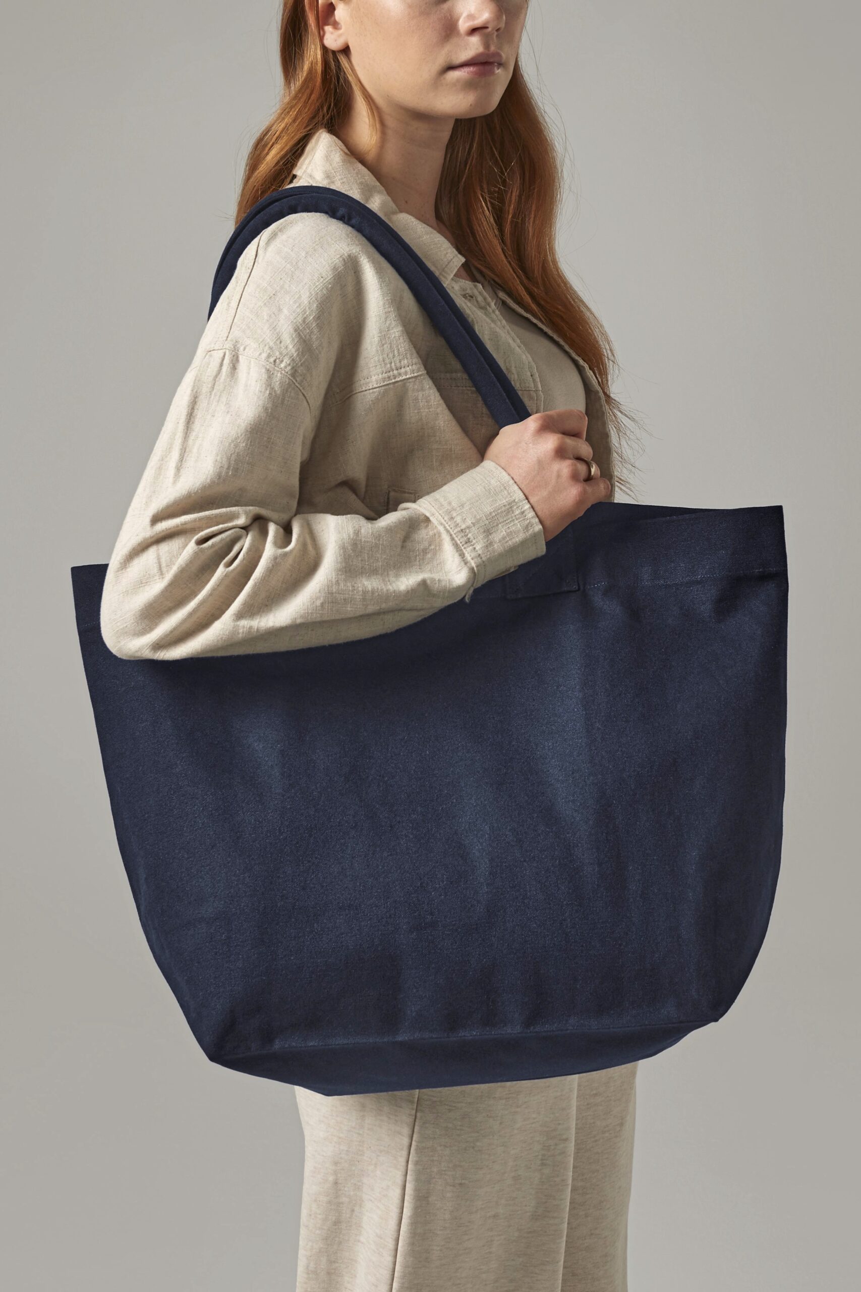 Junge Frau trägt das Fairtrade Cotton Deck Bag W626 Farbe navy